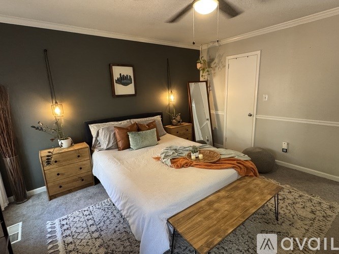 A bedroom with a bed, dresser, and mirror.