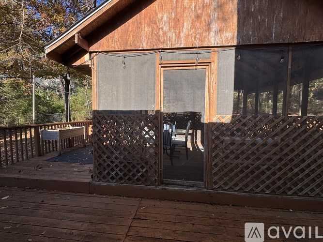 A wooden deck with a lattice fence and a house with a window.