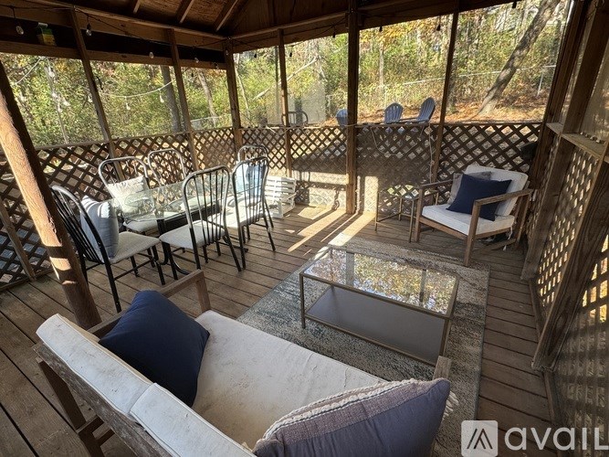 A wooden deck with a glass table and chairs.