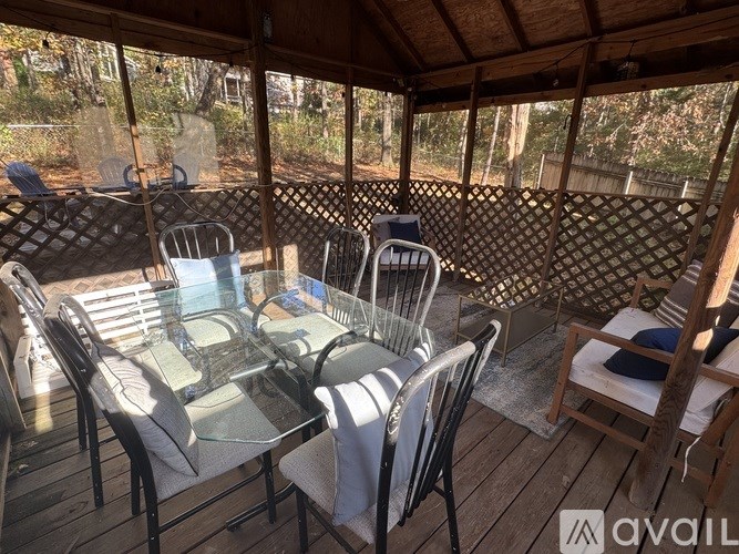 A wooden deck with a glass table and chairs.