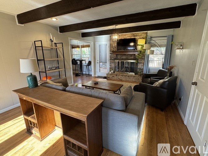 A living room with a wooden desk and a grey couch.