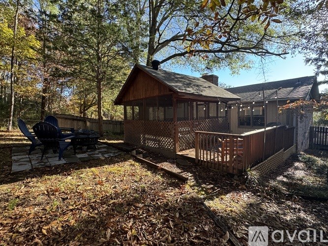 A house with a deck and a patio surrounded by trees.