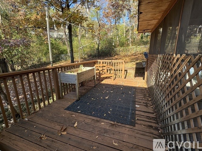 A wooden deck with a railing and a black mat in the middle.