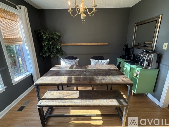 A dining table with a wooden top and metal legs is in the center of the room.