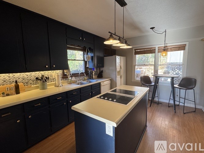 A kitchen with black cabinets and a white countertop.