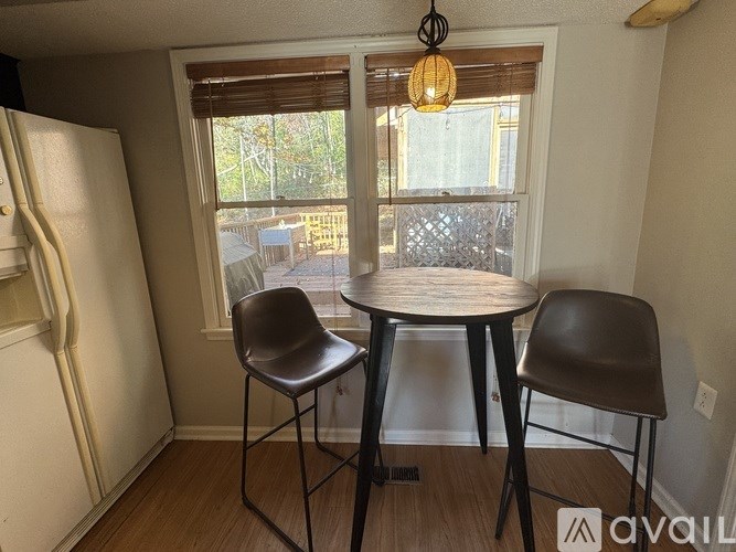 A small dining room with a round table and two chairs.