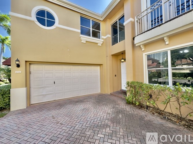 A two-story house with a garage and a balcony.