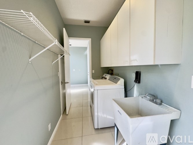 A laundry room with a washer and dryer and a sink.