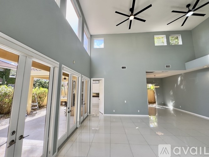 A spacious room with a ceiling fan and sliding glass doors.