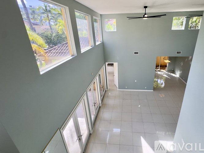 A spacious room with a ceiling fan and large windows.