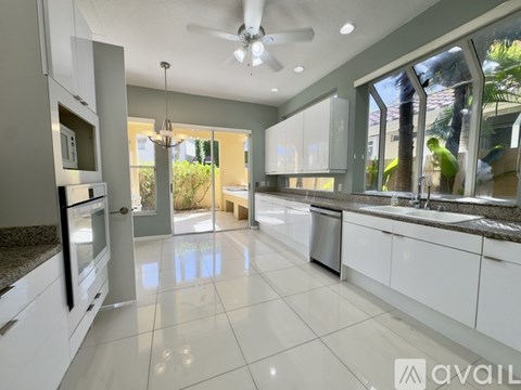 A spacious kitchen with white cabinets and a central island.