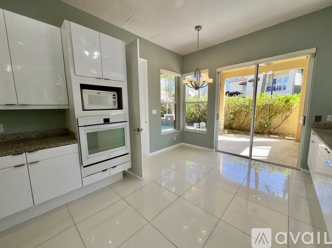 A kitchen with white cabinets and a microwave oven.