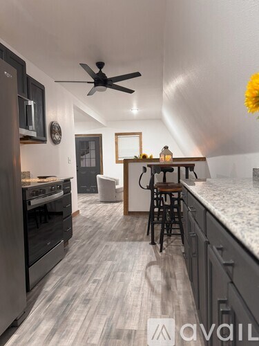 A kitchen with a fan and a bar area.