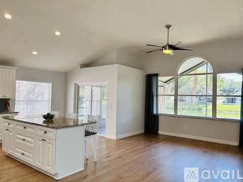 A spacious kitchen with white cabinets and a granite countertop.