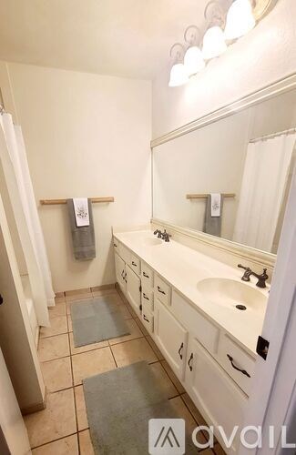 A bathroom with a sink, mirror, and towel rack.