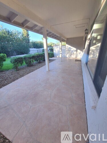 A patio with a tiled floor and a white wall.