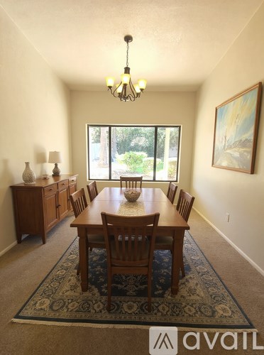 A dining room with a table and chairs.