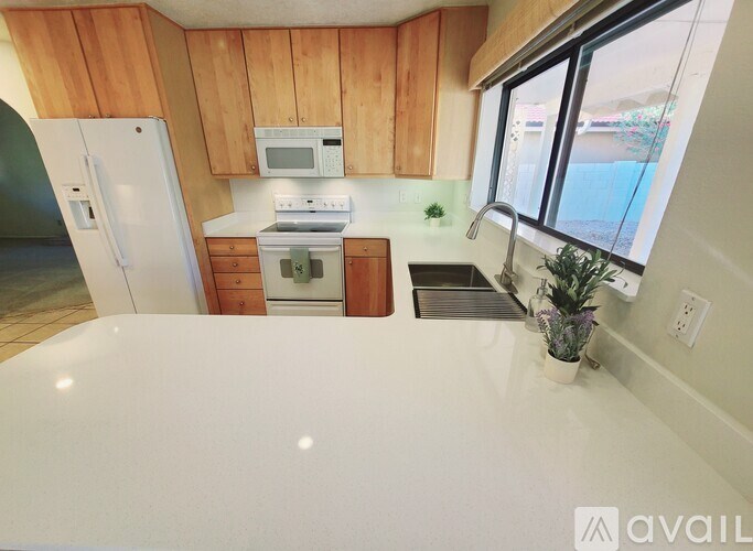 A kitchen with wooden cabinets and a white countertop.