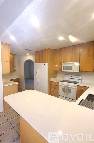 A kitchen with wooden cabinets and a white countertop.