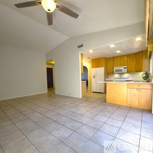 A kitchen with a ceiling fan and a refrigerator.