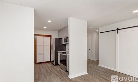 A kitchen with white cabinets and a wooden door.