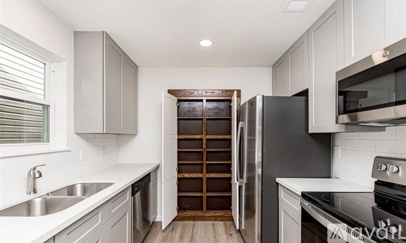 A modern kitchen with a refrigerator, sink, and cabinets.