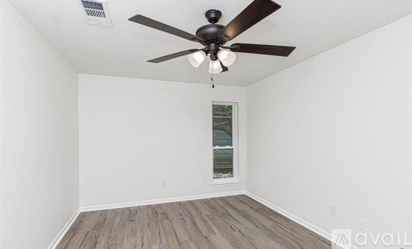 A room with a ceiling fan and a window.