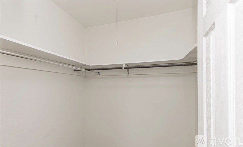 A white room with a slanted ceiling and a white door.