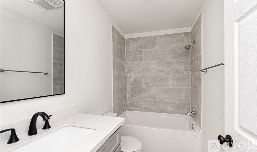 A bathroom with a white sink and a white toilet.