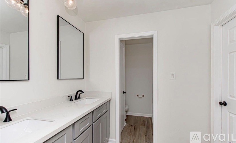 A bathroom with a white countertop and a white door.