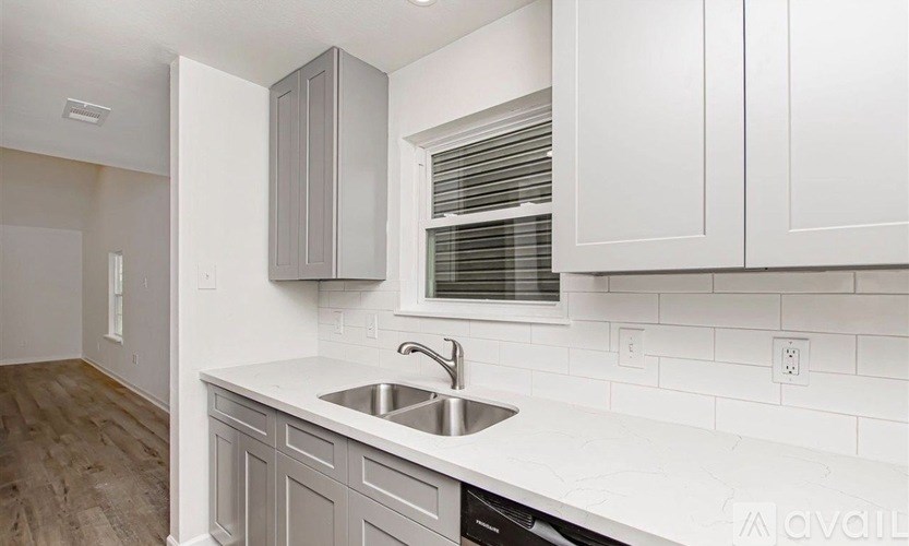 A kitchen with white cabinets and a white countertop.