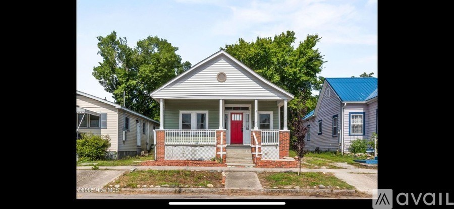 A small house with a red door is for sale.