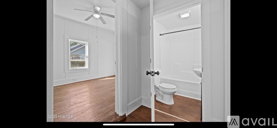 A bathroom with a toilet, sink and a window.