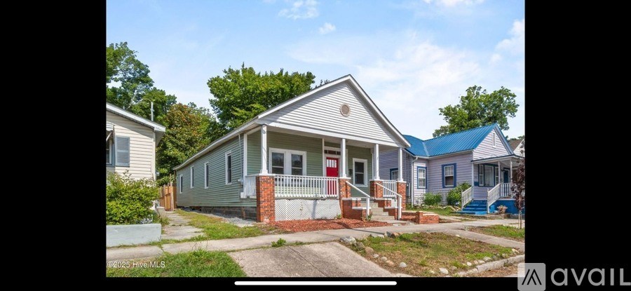 A house with a blue roof is for sale.