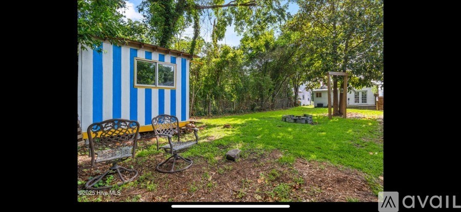 A blue and white striped house with a garden in front.