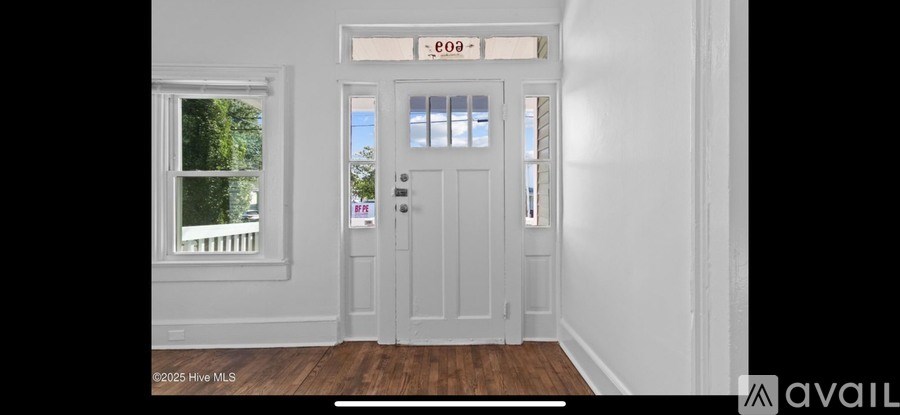 A white door with a glass window and a sign above it that says "e099".