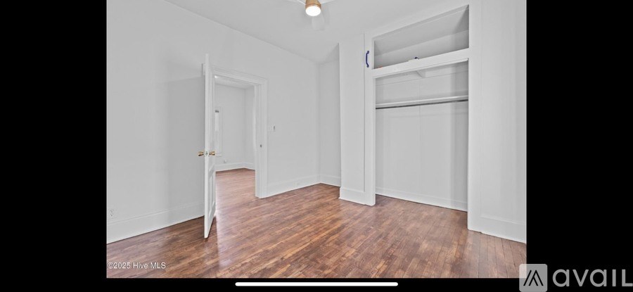 A room with a bunk bed and a doorway leading to another room.