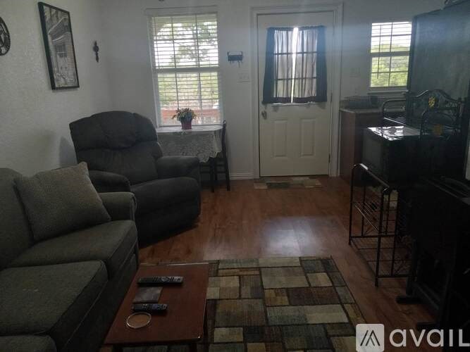 A living room with a grey couch, a brown coffee table, and a television.