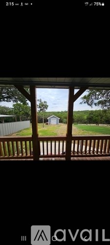 A view from a porch looking out to a yard and a house.