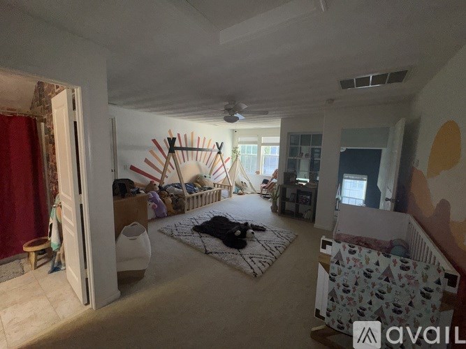 A room with a rug on the floor and a wall clock on the wall.