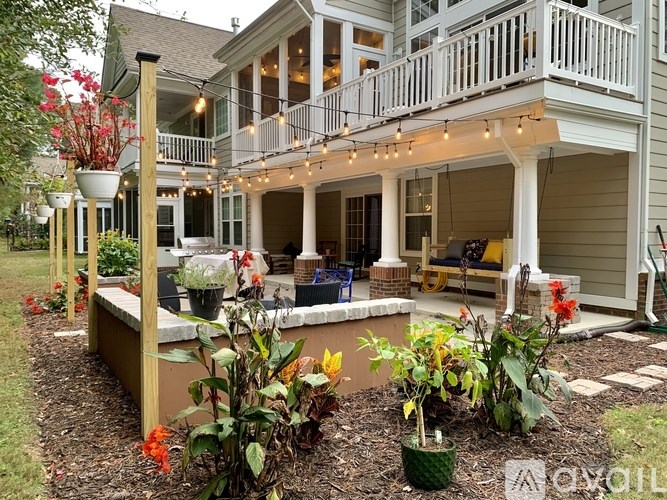 A white house with a balcony and a garden in front.