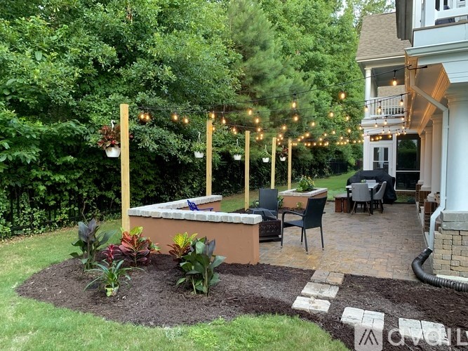 A backyard with a patio, chairs, and a table.