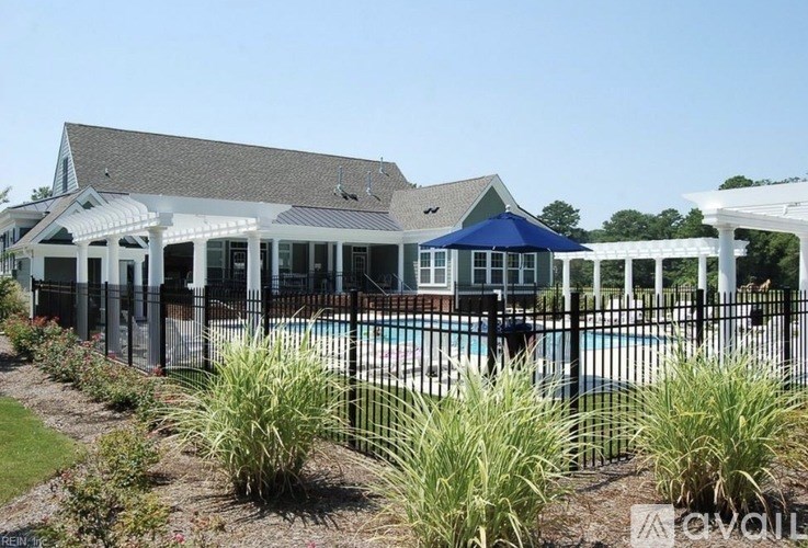 A pool area with a building and a fence.
