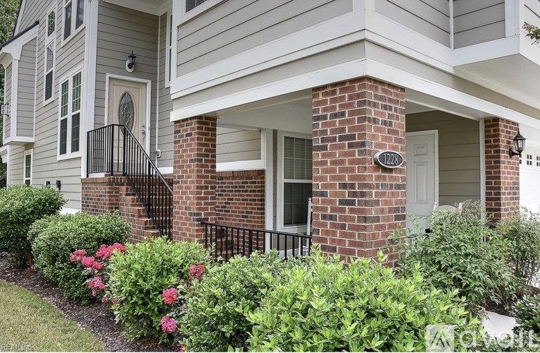 A house with a white door and a brick column.