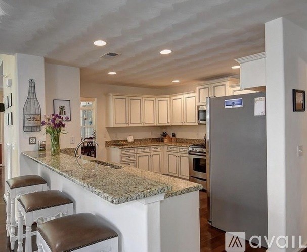 A kitchen with a marble countertop and a refrigerator.