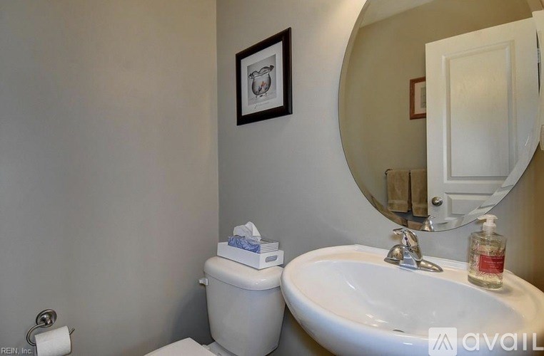 A bathroom with a toilet, sink, and mirror.