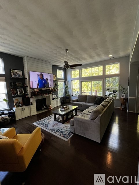 A living room with a yellow chair and a white couch.