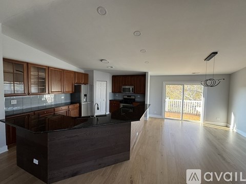 A modern kitchen with dark wood cabinets and a black island.