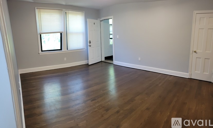 A room with wooden floors and two windows.