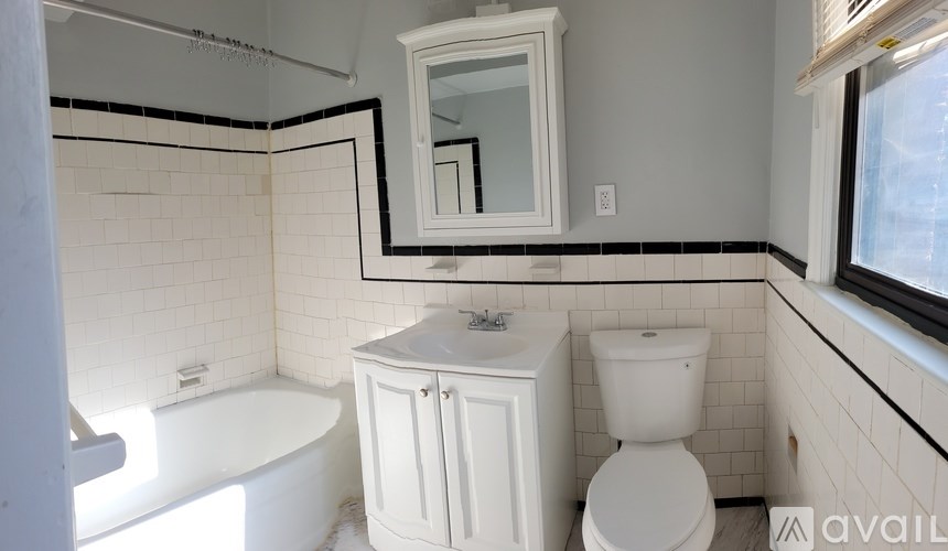 A white bathroom with a tub, toilet, and sink.